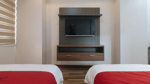 a living room with two beds and a television at RedDoorz Plus @ Bez Tower and Residences San Juan in Manila