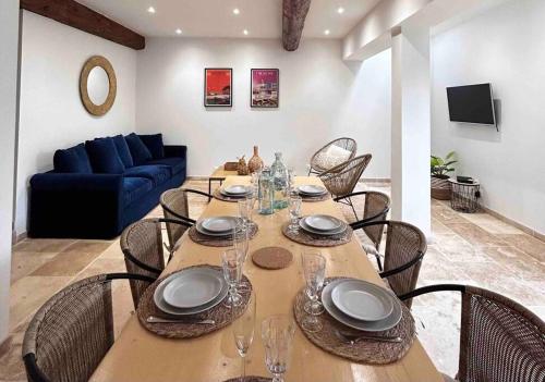 uma mesa de jantar com cadeiras e um sofá azul em Le M37 em Carcassonne