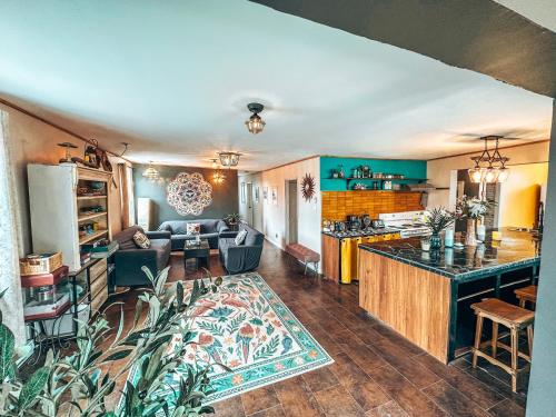 a large living room with a kitchen and a living room at Auberge Mandala in Saint Mathieu Du Parc