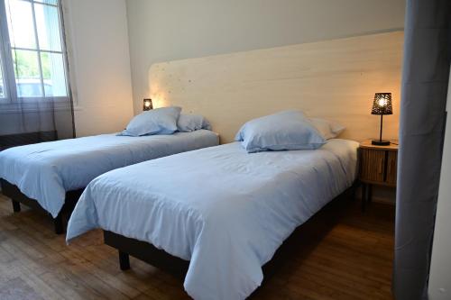 Cette chambre comprend 2 lits avec des draps et des oreillers blancs. dans l'établissement Les escales Périgourdines, Laura, 3 étoiles, à Trémolat