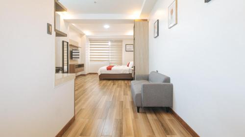 a living room with a chair and a bedroom at RedDoorz Plus @ Bez Tower and Residences San Juan in Manila