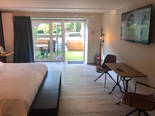 a hotel room with a bed and a desk and a table at Hotel La Librairie in Durbuy