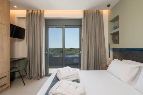 a hotel room with a bed and a large window at Aspect Luxury Apartment I in Galangádhos