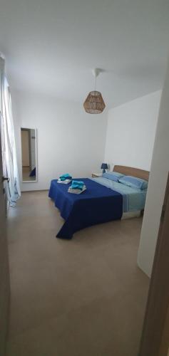 a bedroom with two beds with a blue comforter at La Dimora del Salento in Torre Lapillo