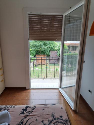 an open sliding glass door with a view of a yard at CASA BEDIN in Zovencedo