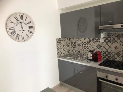 une cuisine avec une grande horloge murale dans l'établissement Appartement atelier dans vieux blois, à Blois