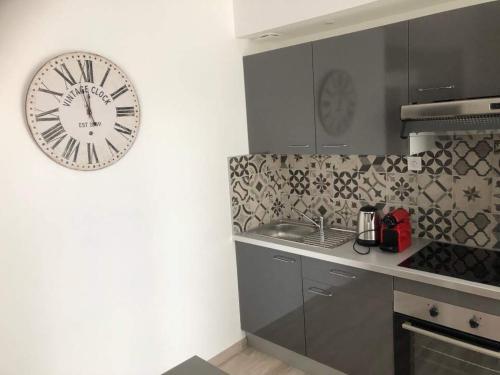 eine Küche mit einer großen Uhr an der Wand in der Unterkunft Appartement atelier dans vieux blois in Blois