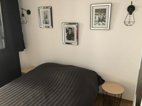- une chambre avec un lit et trois photos sur le mur dans l'établissement Appartement atelier dans vieux blois, à Blois