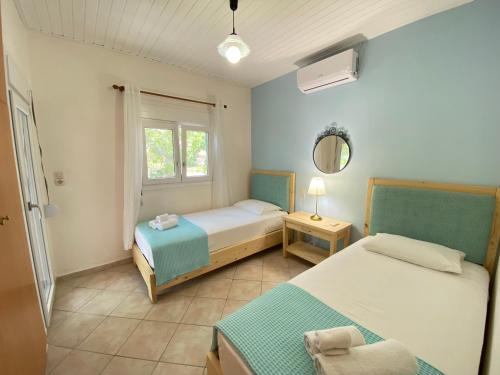 1 dormitorio con 2 camas y ventana en Vaia Villas en Mochlos