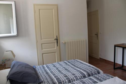 a bedroom with a bed and an open door at Bastide Saint Bernard in Le Thoronet