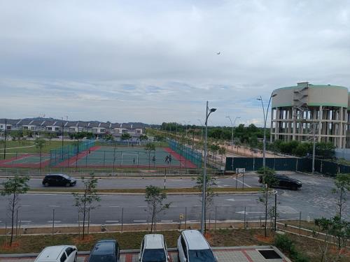 a parking lot with parked cars and a tennis court at Aisy Homestay Putrajaya Cyberjaya KLIA in Kampung Dengkil