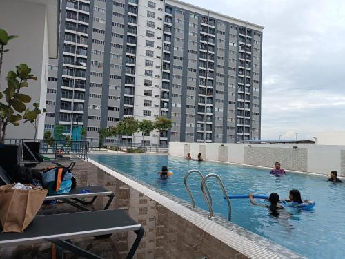 persone che nuotano in una piscina in un edificio di Aisy Homestay Putrajaya Cyberjaya KLIA a Kampung Dengkil