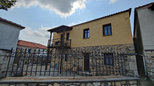 a building with a fence in front of it at The Stone House in Halkidiki in Vávdhos