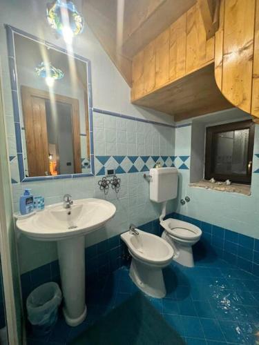 a bathroom with a sink and a toilet and a mirror at Il Borgo della Zittola in Montenero Val Cocchiara