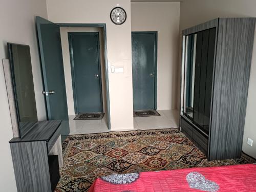 a room with two doors and a clock on the wall at Aisy Homestay Putrajaya Cyberjaya KLIA in Kampung Dengkil