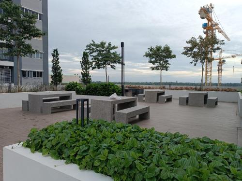 a group of benches and plants in front of a building at Aisy Homestay Putrajaya Cyberjaya KLIA in Kampung Dengkil