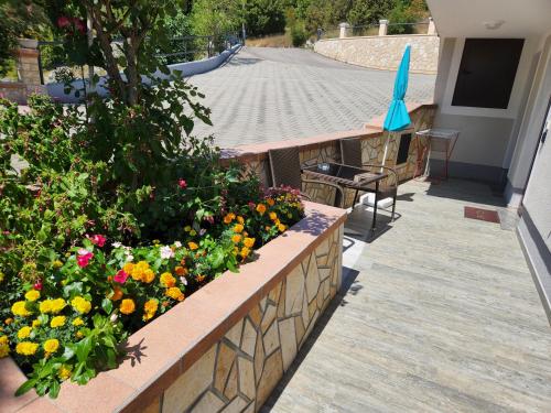 a retaining wall with flowers and an umbrella on a building at Apartment Podini in Brseč