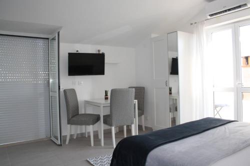 a bedroom with a bed and a table and chairs at Apartments Grković Trsteno Adventure Experience Accommodation 1 in Dubrovnik