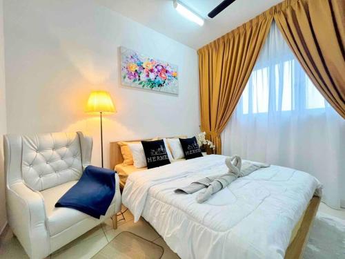 una camera con un letto bianco e una sedia di Alanis Studio Suite {shortstay} a Sepang