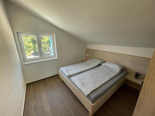 a small bedroom with a bed and a window at BEACHFRONT VILLA Murter in Murter