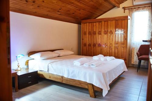 1 dormitorio con 1 cama con toallas en İlçayto Suites, en Foca