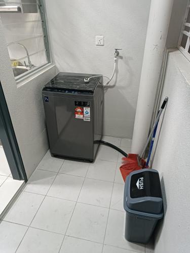 a room with a trash can and a washing machine at Aisy Homestay Putrajaya Cyberjaya KLIA in Kampung Dengkil