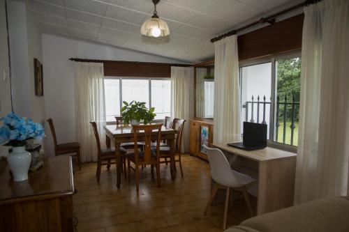 西圭伊羅的住宿－LA CASA DEL RÍO - A 10 min de Santiago，厨房以及带桌椅的用餐室。