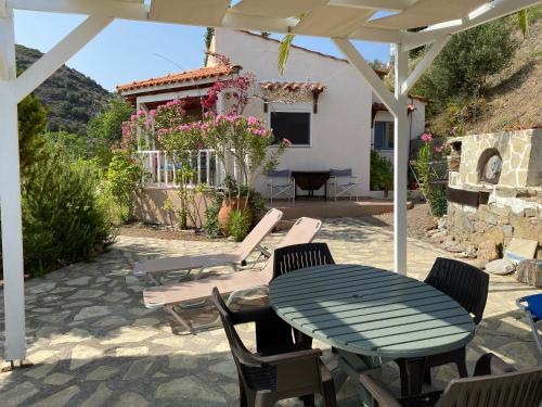 a patio with a table and chairs and a house at Vaia Villas in Mochlos
