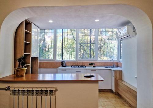 eine Küche mit einem großen Fenster und einem Waschbecken in der Unterkunft Золотой квадрат in Almaty