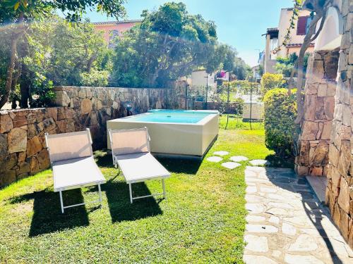 2 sillas y bañera en un patio en Villetta Bouganville, en Budoni