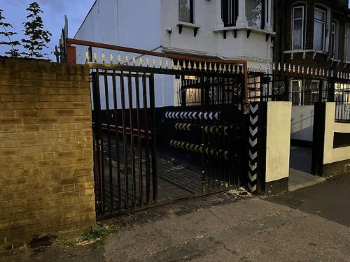 a black iron gate in front of a house at Super spacious, Grnd Floor Flat in London