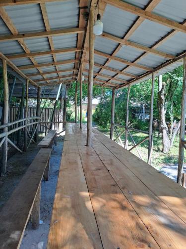 a large wooden table with benches under a roof at Guesthouse Luka in Martvili