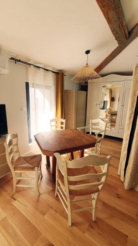 une salle à manger avec une table et des chaises en bois dans l'établissement Grand studio de charme en hypercentre, à Sète