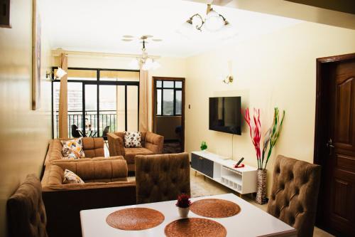 een woonkamer met een bank en een tafel bij Furnished 2 bedroom apartment in Kilimani in Nairobi