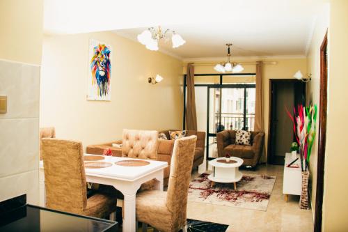 een woonkamer met een tafel en stoelen bij Furnished 2 bedroom apartment in Kilimani in Nairobi