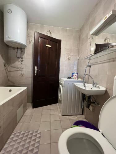 La salle de bains est pourvue de toilettes, d'un lavabo et d'une porte. dans l'établissement City life apartman, à Herceg-Novi