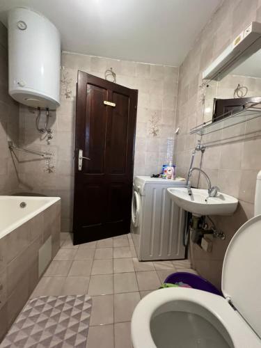 a bathroom with a toilet and a sink and a door at City life apartman in Herceg-Novi