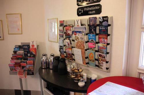 a room with a table and a sign on the wall at Hotel Nordic in Norderstedt