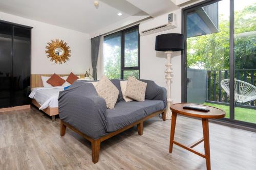 a bedroom with a couch and a bed and a table at The deck condominium by Ryan, walking to patong beach in Patong Beach