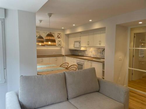 a living room with a couch and a kitchen at Apartamento a estrenar en Centro Gijón. FIBRA-TV in Gijón
