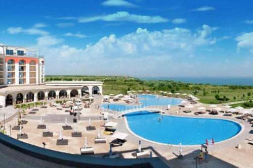 ein Bild eines Resorts mit zwei Pools und Sonnenschirmen in der Unterkunft Villa L3 Lighthouse Golf Resort Balchik in Baltschik