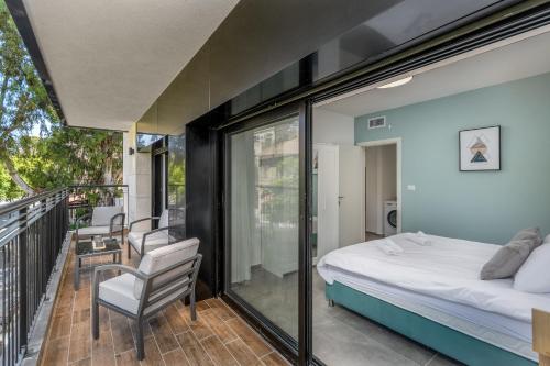 1 dormitorio con 1 cama y balcón en New Luxury 3 BR - Next the Orient Hotel en Jerusalén