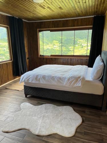 een slaapkamer met een bed en een groot raam bij Yamaç Çam Hotel in Trabzon