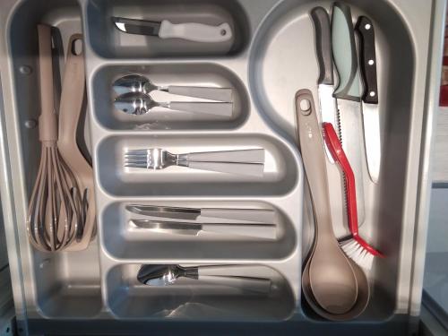 a drawer filled with utensils in a refrigerator at Apartament City Center JAPAN - no smoking, free bottled water, coffea and tea in Koszalin