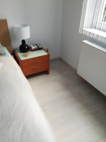 a bedroom with a bed and a table with a lamp at Apartament City Center JAPAN - no smoking, free bottled water, coffea and tea in Koszalin