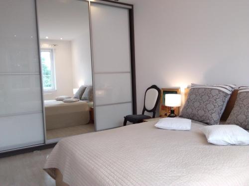 a bedroom with a large white bed and a mirror at Apartament City Center JAPAN - no smoking, free bottled water, coffea and tea in Koszalin