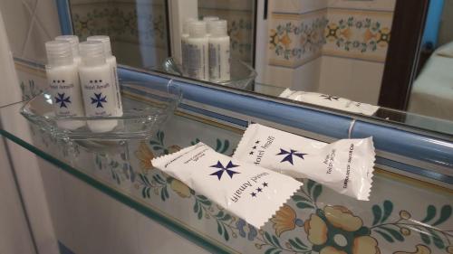 a bathroom counter with a mirror and some towels at Hotel Amalfi in Amalfi