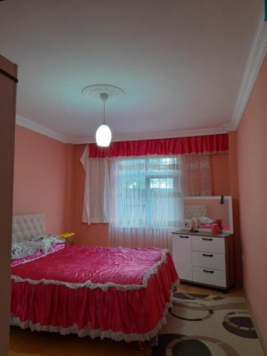 1 dormitorio con cama roja y ventana en Doğa manzaralı ev, 