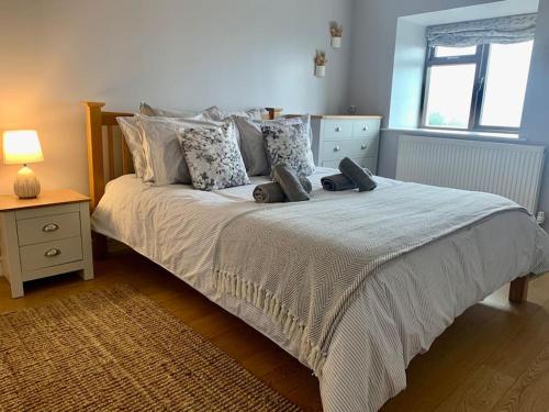 a bedroom with a large bed with pillows at Welsh cottage coastal retreat with stunning views in Pen-y-groes