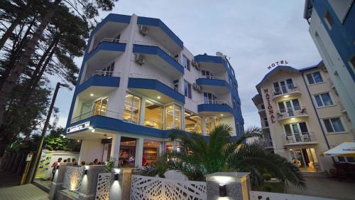 un edificio azul y blanco con gente parada frente a él en National+ en Ureki